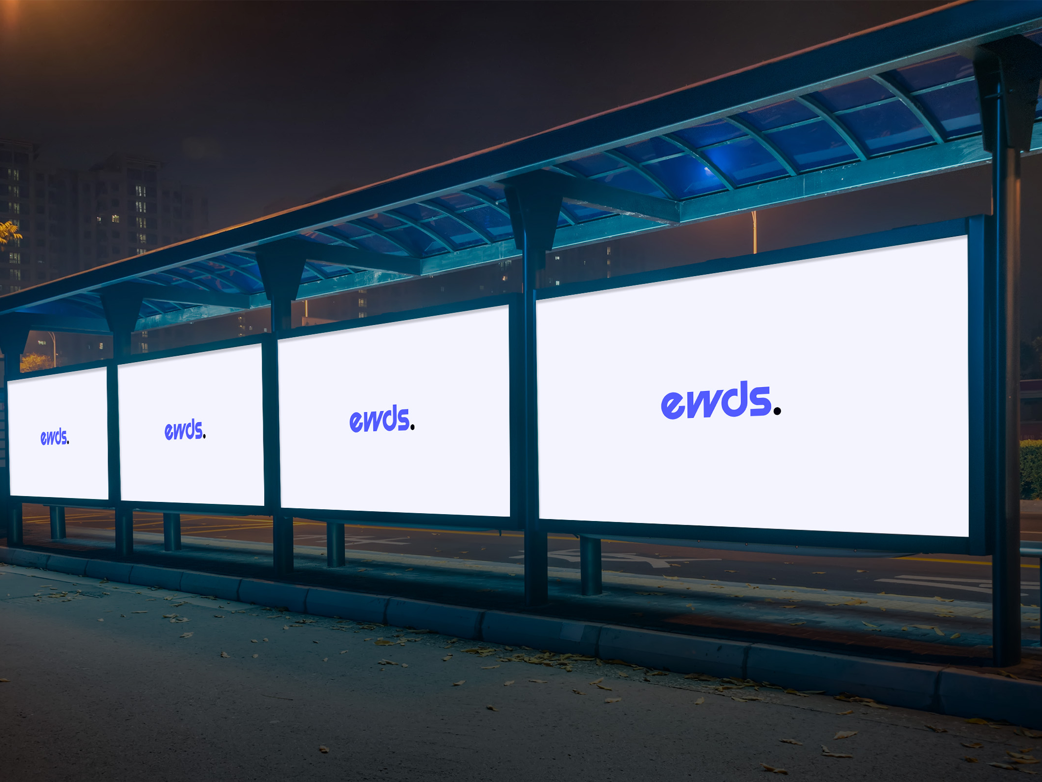 A bus stop at night displaying three illuminated billboards with the word 