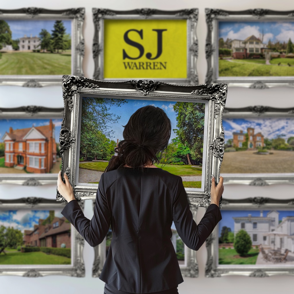 A woman holding a picture frame, ready to make new memories—brought to you by SJ Warren Estate Agents.