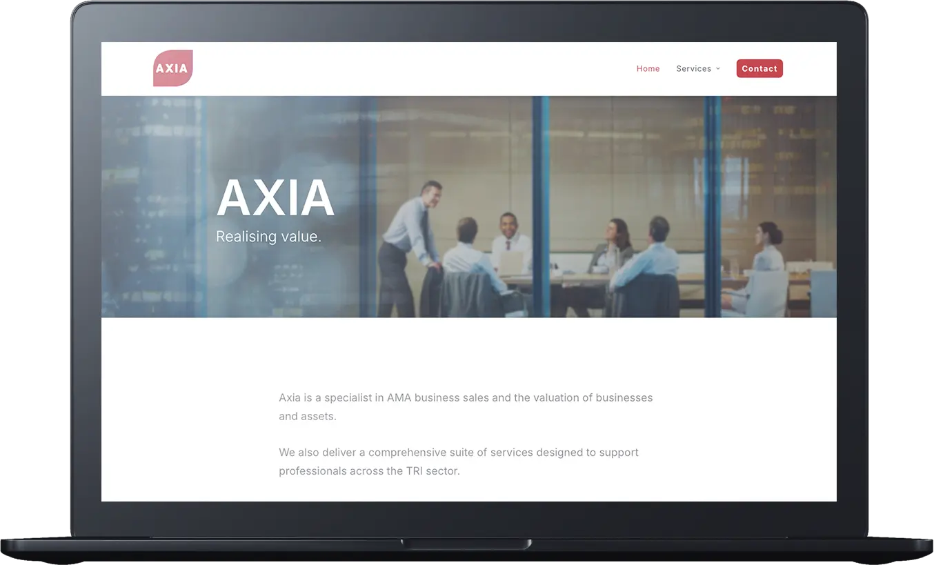 A laptop screen displays a business website for Axia Valuation Services, featuring a team meeting photo and navigation links for Home, Valuation Services, and Contact.